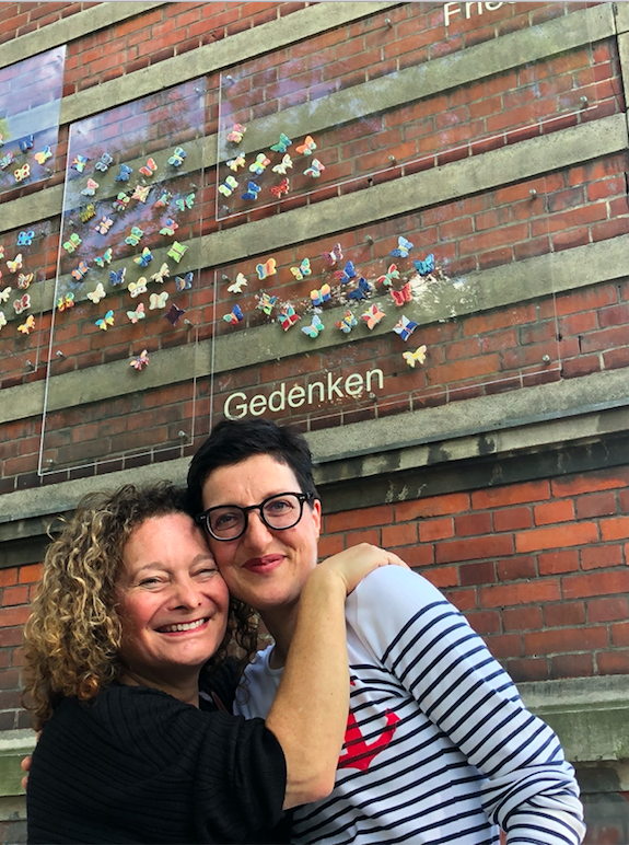 Nicole and Cheryl embrace in front of the installation at Bewegte Grundschule.